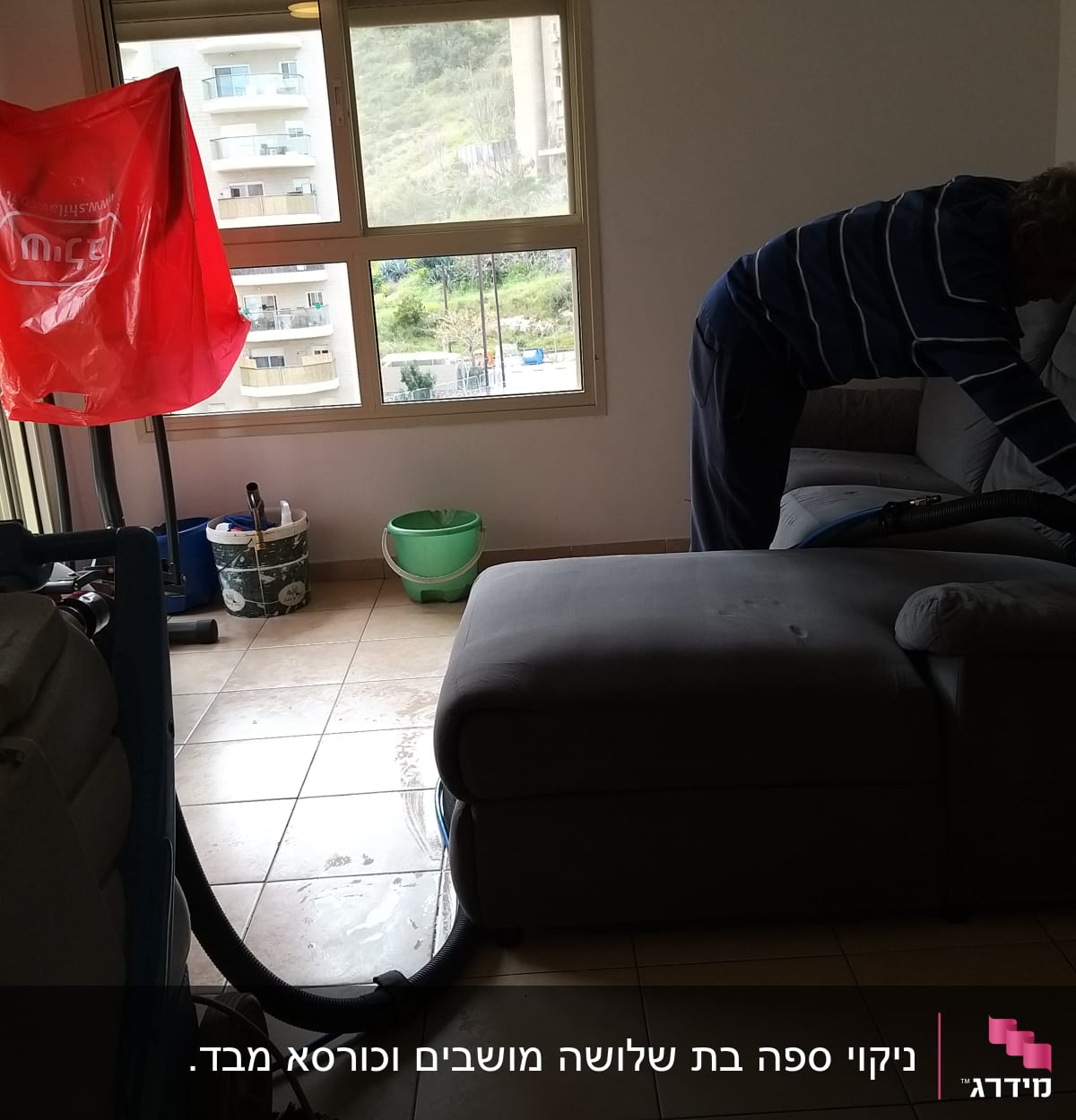 אדם מנקה ספה עם שואב אבק מקצועי